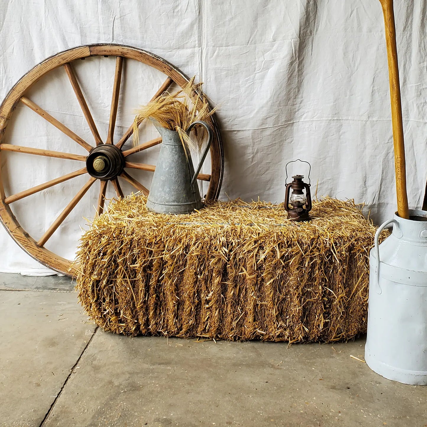 Décor ferme avec ballot de paille, roue de charu, pot à lait