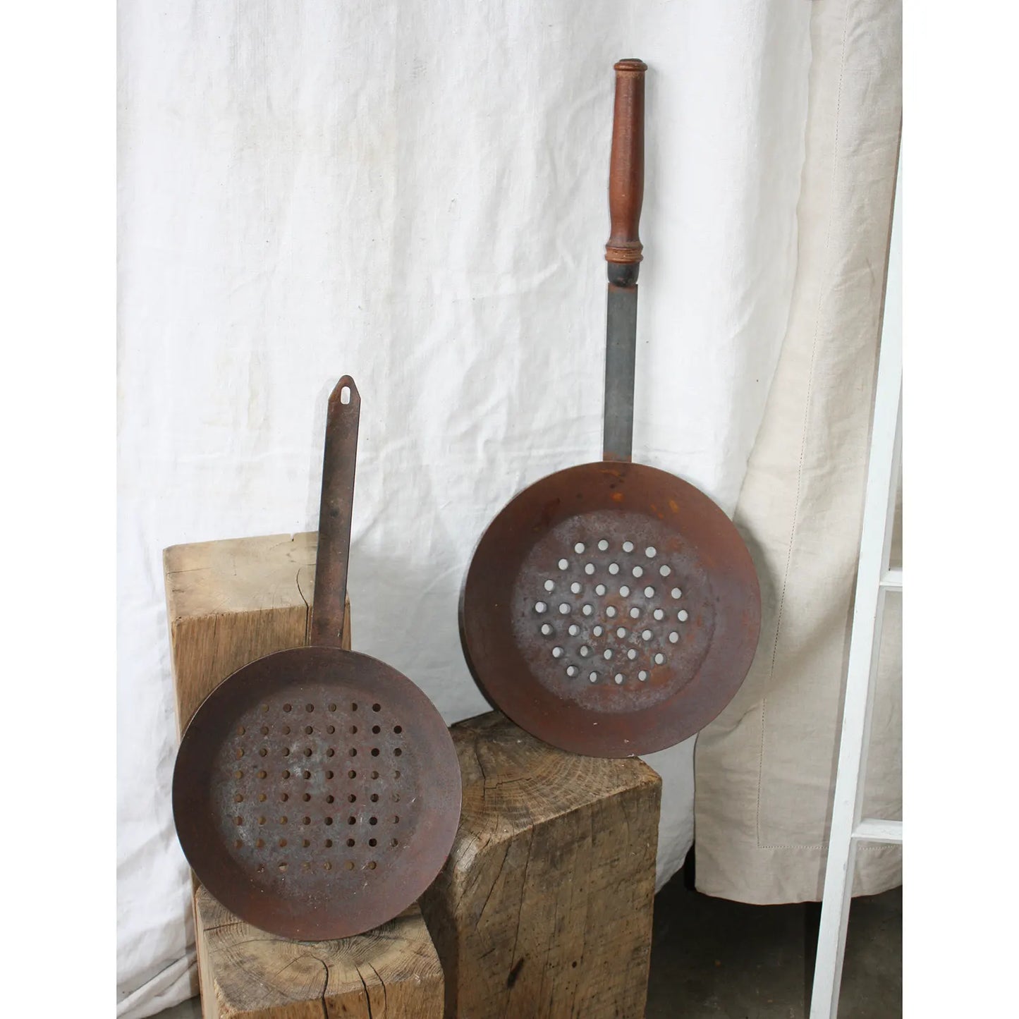 Deux poêles à marrons sur rondins