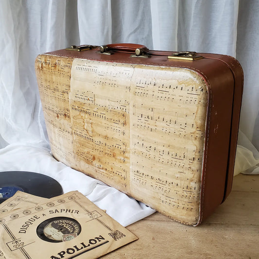grande valise posée avec partitions de musiques