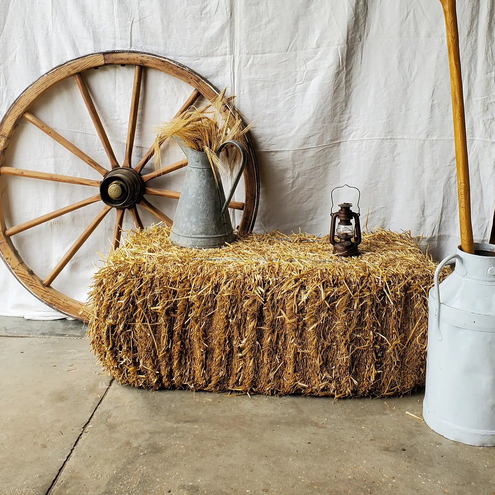 Décor ferme avec ballot de paille, roue de charu, pot à lait