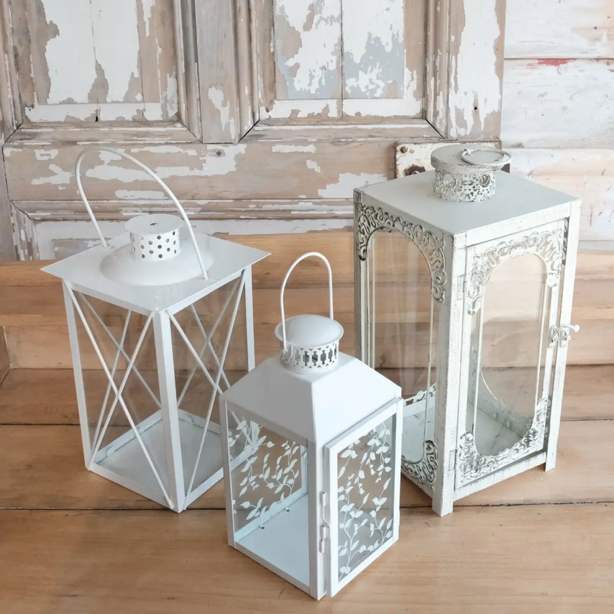 Trois lanternes blanches en métal et verre