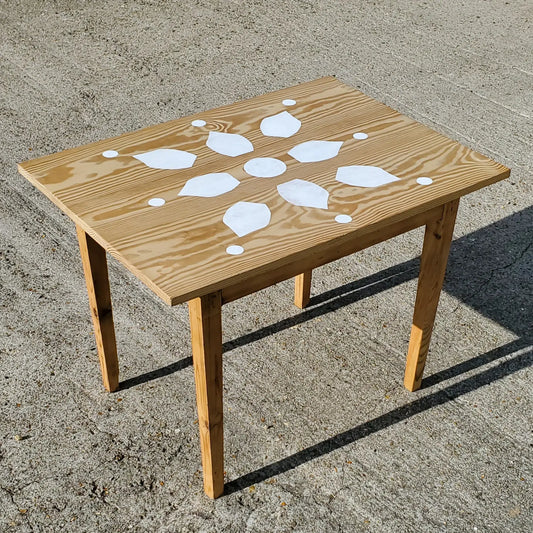 Table rectangulaire en bois avec motif fleur sur le plateau pour thème bohème